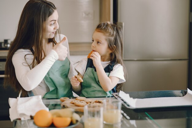 Mother and daughter sitting in a kitchen with cookies