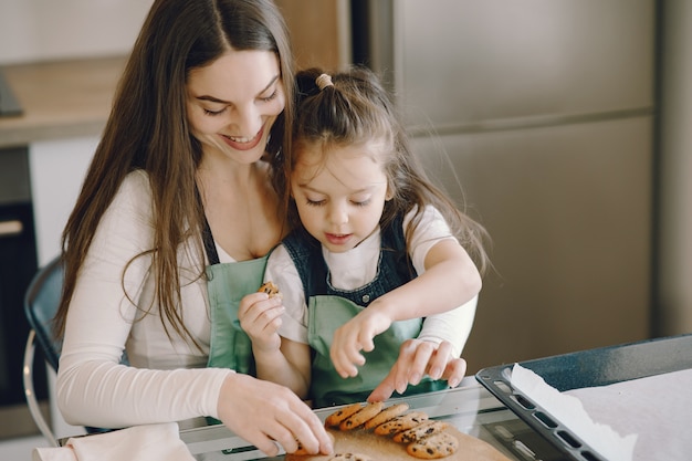Mother and daughter sitting in a kitchen with cookies