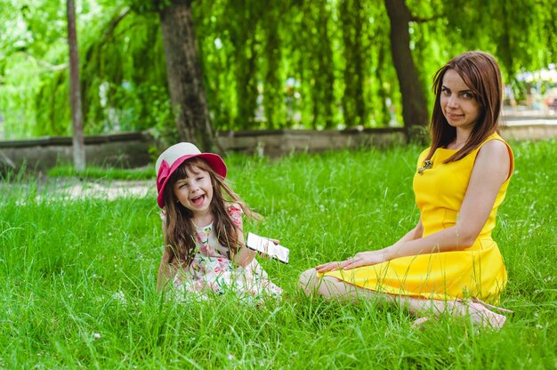 公園の芝生の上に座って母と娘