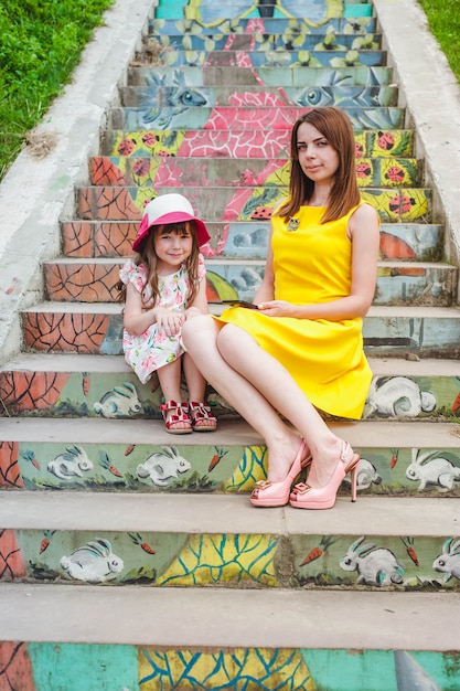 Free photo mother and daughter sitting on stairs