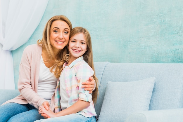 Mother and daughter sitting together and hugging