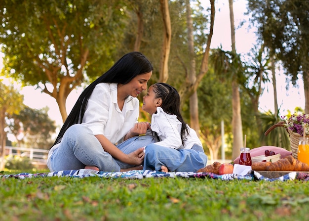 Free photo mother and daughter spending time together outside at the park for mother's day