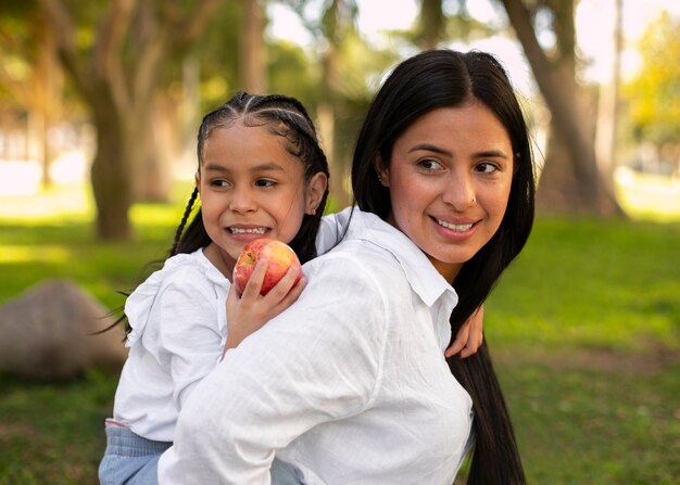 Mother and daughter spending time together outside at the park for mother's day