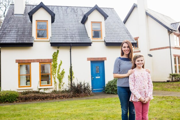 Mother and daughter standing in lawn