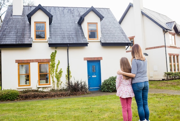 Mother and daughter standing in lawn