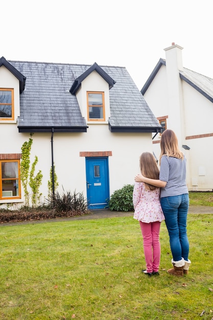 Mother and daughter standing in lawn