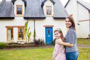 Free photo mother and daughter standing in lawn