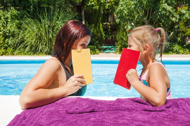 Mother and daughter standing in pool