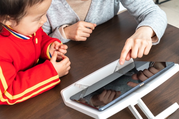 Mother and daughter study online class with tablet computer