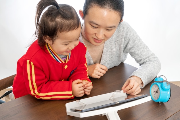 Mother and daughter study online class with tablet computer