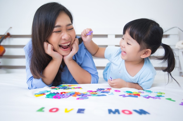 Mother and daughter studying the alphabet