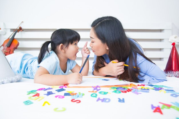 Mother and daughter studying the alphabet