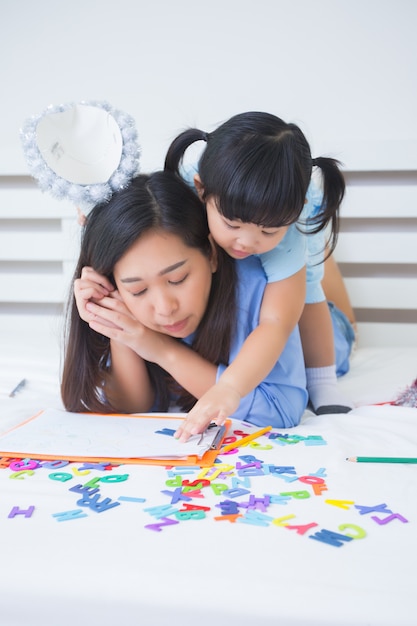 Mother and daughter studying the alphabet