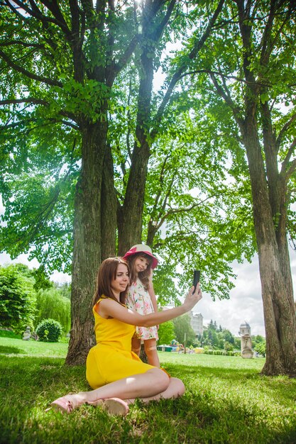 Mother and daughter taking an auto photo in a park