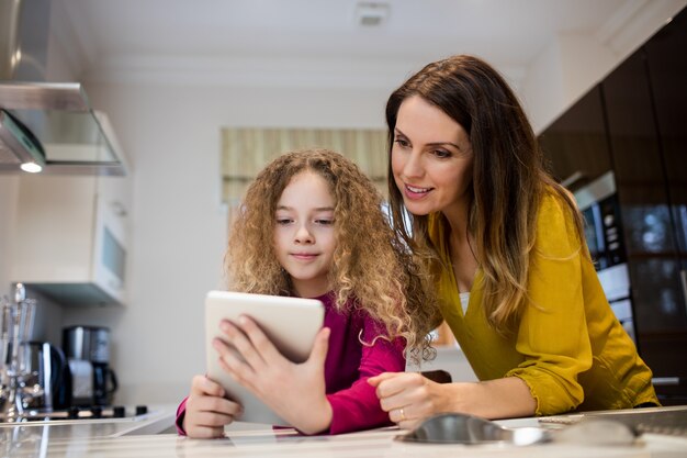 Мать и дочь принимая селфи от цифрового планшета