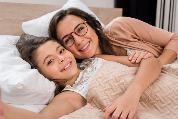 Мать и дочь, принимая selfie вместе в постели