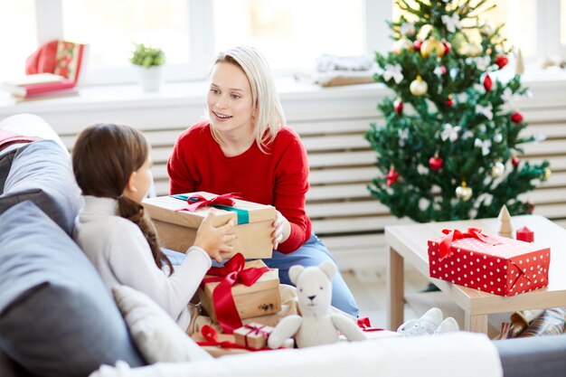 Mother and daughter unwrapping Christmas presents