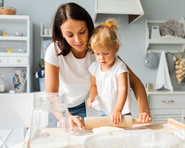 Mother and daughter using kitchen roller