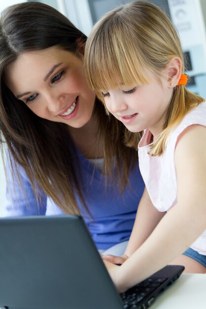 Mother and daughter using laptop in the kitchen