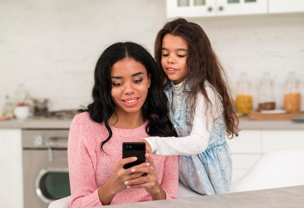 Mother and daughter using mobile