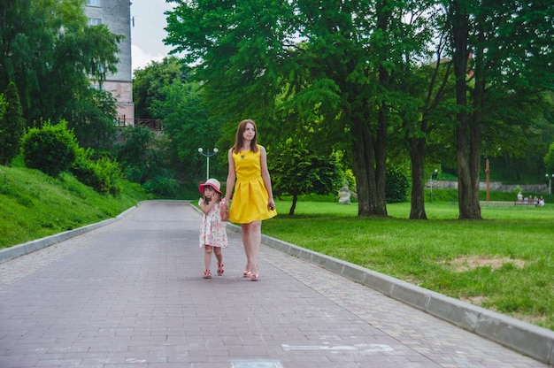 Mother and daughter walking on an asphalted road