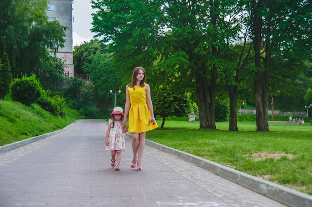 Mother and daughter walking on an asphalted road
