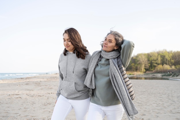 Mother and daughter walking on the beach together