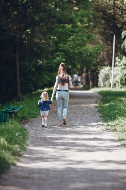 母と娘は、未舗装の道路の上を歩い