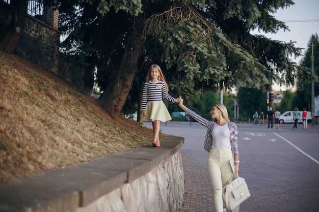 Madre e figlia che camminano mano nella mano