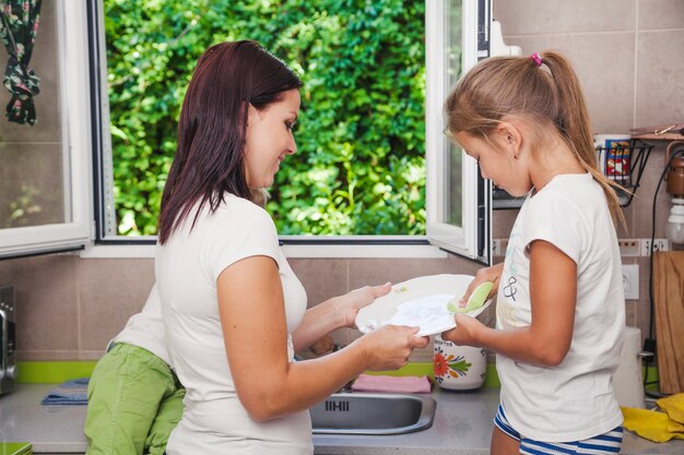 Mother and daughter washing dishes