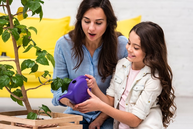 Mother and daughter watering the plant