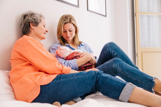 Mother and daughter with baby in bedroom