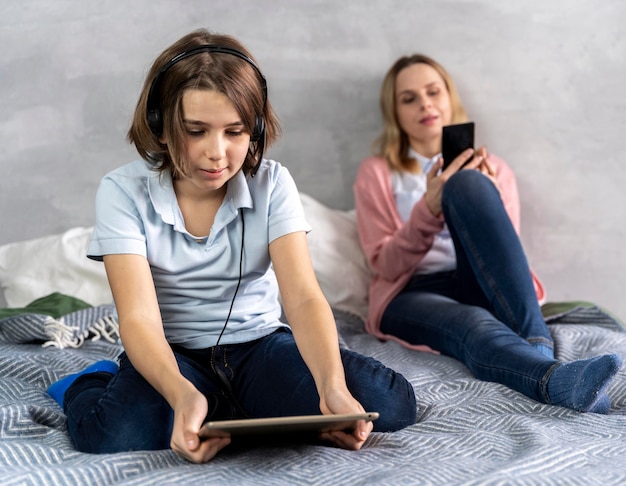 Mother and daughter with devices