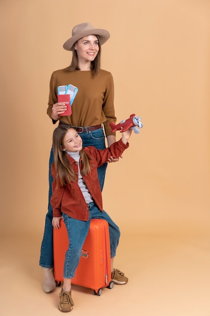 Mother and daughter with luggage ready for traveling