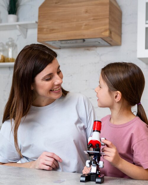 Mother and daughter with microscope doing science experiments