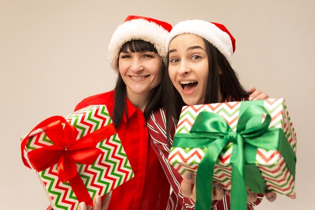 Mother and daughter with Santa hat and gift box