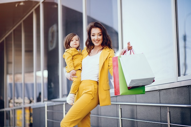 街で買い物袋を持つ母と娘