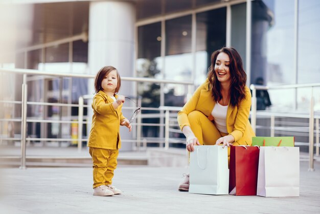 街で買い物袋を持つ母と娘