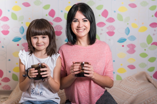 Mother and daughter with tea cups 