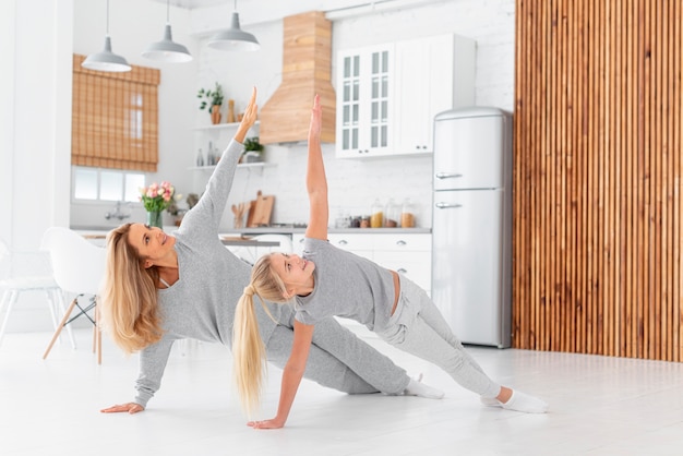 Free photo mother and daughter working out indoor