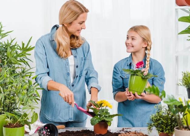 Mother and daughter working together in greenhouse