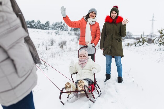 Mother and daughters waving hands for camera