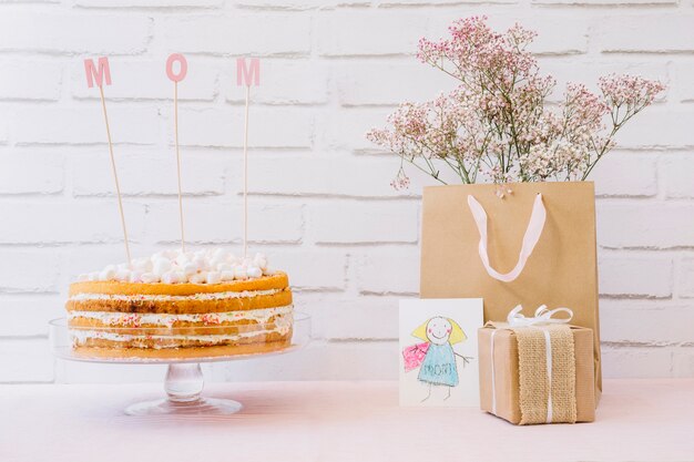 Mother day concept with tasty cake and flowers in bag