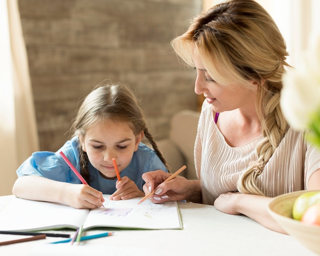 Бесплатное фото Мать делает домашнее задание вместе с дочерью