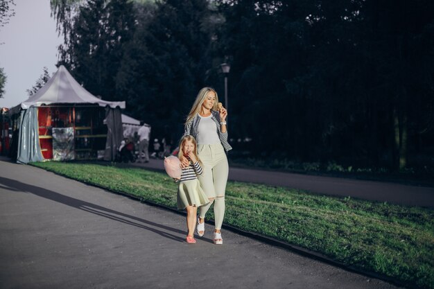 Mother eating an ice cream and her daughter pink cloud