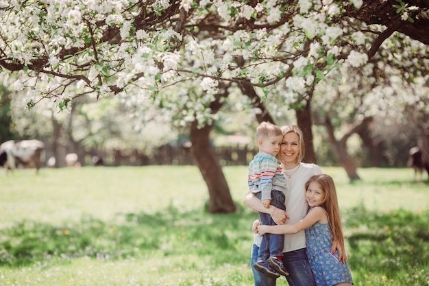 The mother embarcing her children and standing in the park