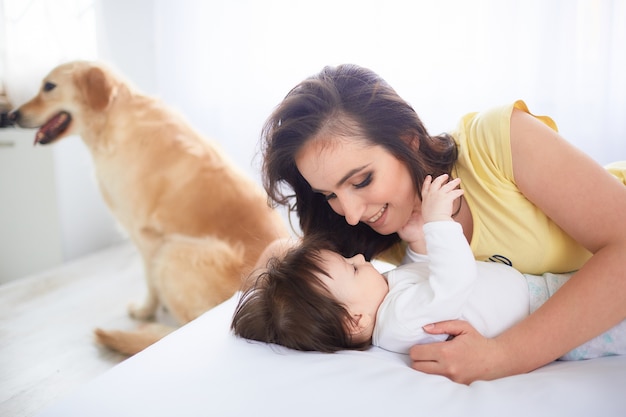 The mother embraces her daughter and lies on the bed