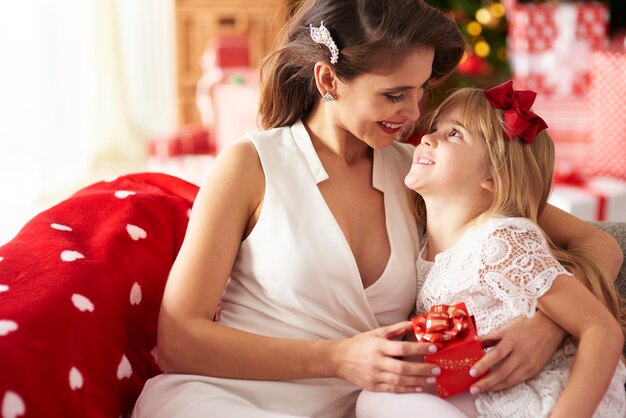 Mother embracing daughter and looking at her 
