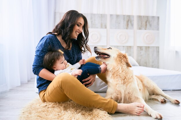 The mother embracing her daughter and sitting near dog