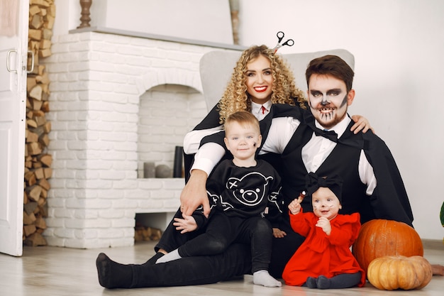 Mother father and children in costumes and makeup. Family prepare to celebration of Halloween.